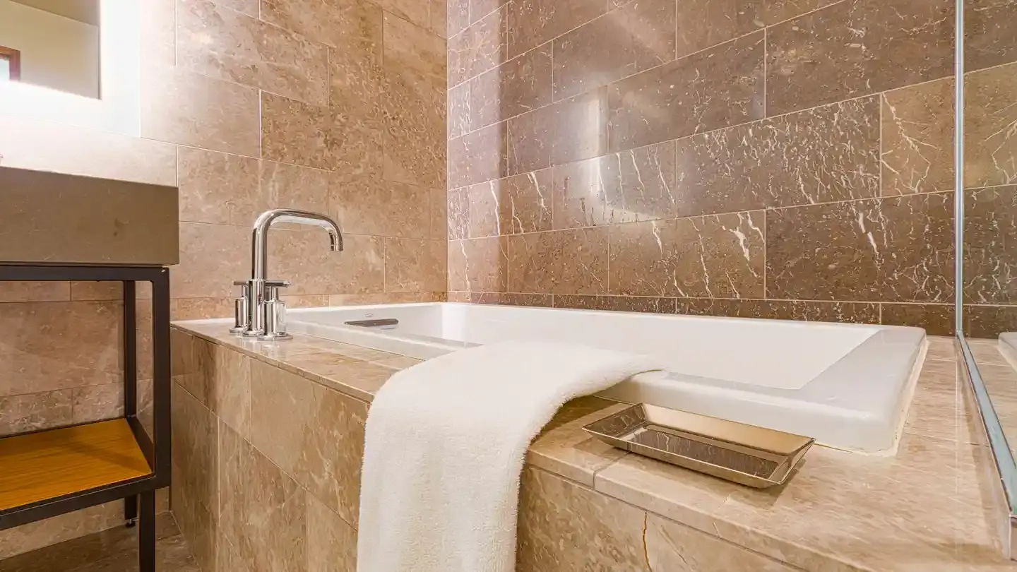 Badewanne mit Natursteinfliesen in Marmoroptik