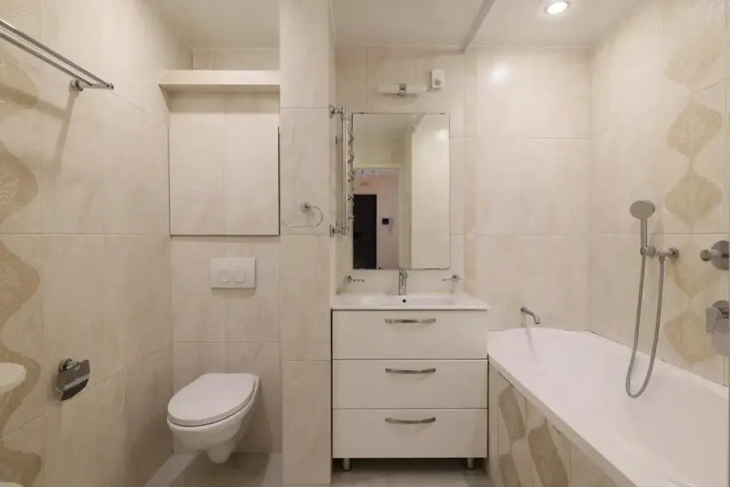 Saniertes Badezimmer mit Badewanne, Hängewaschtisch und Wandfliesen