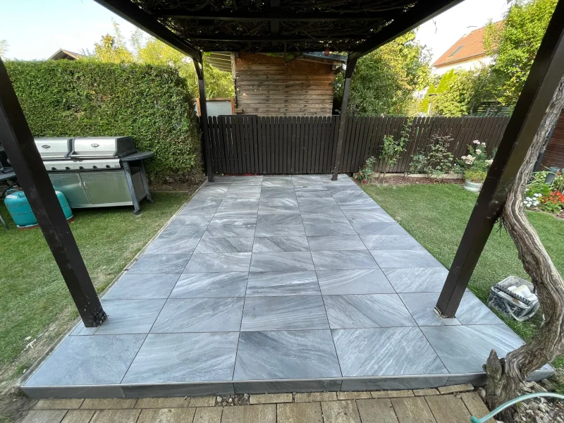 Terrassenplatten unter der Pergola verlegt
